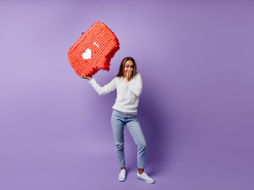 Studio shot of happy girl in jeans thinking about internet. Full
